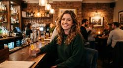 Woman smiling at a stylish bar open to meeting someone new